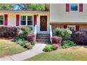 Inviting entryway with a wooden door, decorative wreath, and colorful landscaping enhancing the home's curb appeal at 4172 Whispering Forest Ct, Lilburn, GA 30047