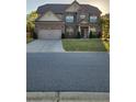 Well maintained two-story brick home with attached two-car garage, green lawn, and professional landscaping at 1645 Dahlia Dr, Cumming, GA 30040