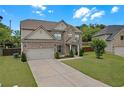 Attractive two-story house featuring a well-maintained lawn, an attached garage, and lush landscaping at 1645 Dahlia Dr, Cumming, GA 30040