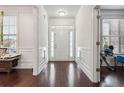 Bright foyer featuring hardwood floors, white wainscoting, and a view of the front door and transom window at 1645 Dahlia Dr, Cumming, GA 30040