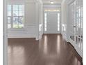 Elegant foyer with hardwood floors, white wainscoting, transom windows, and French doors to office at 1645 Dahlia Dr, Cumming, GA 30040