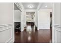 Hallway with hardwood floors, white wainscoting, and views into the living room and dining areas at 1645 Dahlia Dr, Cumming, GA 30040