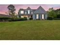 Charming two-story home with blue shutters and a lush green lawn during twilight at 200 Boca Ciega Ct, Alpharetta, GA 30022