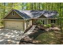 Beautifully landscaped home with a two-car garage, complemented by a charming walkway and lush greenery at 191 Orchard Dr, Canton, GA 30115