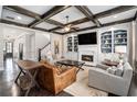 Elegant living room featuring a coffered ceiling, a cozy fireplace, and custom built-in shelving at 2005 Etris Manor Dr, Roswell, GA 30075