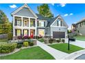 Beautifully landscaped front yard with a two-story home, featuring a red front door and a two-car garage at 2582 Corey Park Dr, Loganville, GA 30052