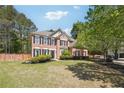 Lovely brick home with manicured lawn and landscaping with mature trees surrounding the property at 715 Aronson Lake Ct, Roswell, GA 30075
