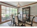 Traditional dining room with dark wood table and chairs, complemented by a large window and decorative lighting fixture at 1423 Fairfield Sw Dr, Lilburn, GA 30047