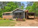 Ranch style home featuring an open carport and inviting screened porch, set on a verdant lot at 160 Oglesby Bridge Rd, Conyers, GA 30094