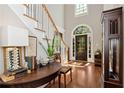 Elegant foyer featuring hardwood floors, a staircase with white railings, and a striking arched doorway at 1485 Mill Place Dr, Dacula, GA 30019