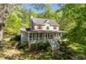Charming two-story home features a welcoming porch, red shutters, and lush landscaping at 1660 Maple Ridge Dr, Loganville, GA 30052