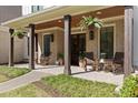Inviting front porch with brick flooring, rocking chairs, wooden pillars, and hanging ferns creates a warm welcome at 284 Hook St, Alpharetta, GA 30009