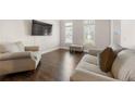 Cozy living room featuring two large sofas, natural light, and hardwood floors at 160 Brookhollow Trce, Alpharetta, GA 30022