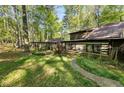 Log cabin with a stone walkway and views of the surrounding trees at 3401 Clay Rd, Austell, GA 30106