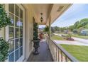 Inviting porch with traditional railing, decorative hanging lantern, and verdant green scenery at 1924 Windburn Ct, Snellville, GA 30078