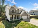 Side view of the two-story house with brick and siding exterior, three-car garage, and beautifully landscaped front yard at 3875 Grandview Manor Dr, Cumming, GA 30028