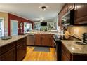 Modern kitchen with granite countertops, stainless steel appliances, and rich wood cabinets, perfect for culinary enthusiasts at 7522 Greens Mill Dr, Loganville, GA 30052