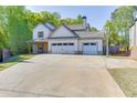 Traditional two-story home showing three-car garage, long driveway, basketball hoop, and landscaped front yard at 110 Legion Dr, Buford, GA 30518