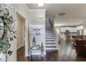 Inviting foyer featuring a staircase, hardwood floors, and an open view into the kitchen and living areas at 110 Legion Dr, Buford, GA 30518