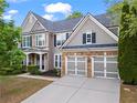Beautiful home with well-maintained lawn, stone accents, and modern garage doors at 203 Setters Rdg, Canton, GA 30115