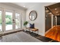Inviting foyer with stone tile, complemented by a stylish bench and bright view through glass doors at 1280 Berkeley Rd, Avondale Estates, GA 30002