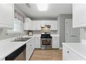 Well-lit kitchen with stainless steel appliances, white cabinets, modern countertops, and new luxury vinyl plank flooring at 2154 Windstream Sw Way, Marietta, GA 30060