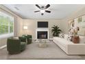 Bright living room with fireplace, modern furniture, neutral tones, and large window for ample natural light at 2154 Windstream Sw Way, Marietta, GA 30060