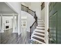Inviting foyer with a staircase, dark wood floors and modern lighting fixtures at 2461 Peregrine Trl, Suwanee, GA 30024