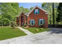 View of the beautiful brick home with a large front lawn, walkway, and lush greenery at 2461 Peregrine Trl, Suwanee, GA 30024