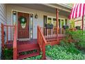 Inviting front porch with a decorative wreath, American flag, and potted plants that create a welcoming entrance at 363 Ridge Run Dr, Hiram, GA 30141