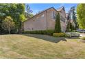 View of home's expansive lawn, mature trees, and neutral siding with brick accents at 3715 Lexington Rd, Tucker, GA 30084