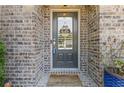 Front door of brick home, featuring a 'welcome' mat and a 'hello' sign at 3715 Lexington Rd, Tucker, GA 30084