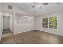 The primary bedroom has wood-look flooring, a ceiling fan, and natural light at 464 Meadowbrook Dr, Mcdonough, GA 30253