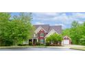 Charming brick home with a lush green lawn and mature trees, offering great curb appeal and a welcoming facade at 51 Sagemont Ct, Acworth, GA 30101