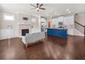 Open-concept living room with hardwood floors, fireplace, and a kitchen island at 4343 Ainsley Mill Ln, Duluth, GA 30097