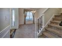 Inviting entryway featuring a decorative front door, staircase, and elegant chandelier lighting the adjacent dining area at 5221 Huntcrest Sw Pl, Mableton, GA 30126
