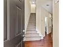 Bright foyer featuring hardwood floors and staircase with contemporary design, leading to upstairs at 7705 Bellmist Dr, Fairburn, GA 30213