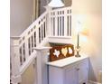 Home's entryway features a white stairway with a wood stained accent piece and lamp on top of a decorative table at 821 Tramore Ct, Powder Springs, GA 30127