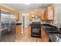 Modern kitchen with black appliances, granite countertops, and wood cabinetry at 1000 Brushystone Dr, Loganville, GA 30052