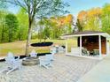 Outdoor living area with fire pit, built-in grill, and covered seating area at 345 Etheridge Rd, Auburn, GA 30011