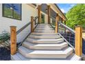 Front entrance showcasing a modern staircase leading to a covered porch with stylish railings and wooden posts at 345 Etheridge Rd, Auburn, GA 30011