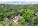 Aerial view of a brick two-story home, surrounded by mature trees and a well maintained lawn at 4213 Schooner Ne Ct, Roswell, GA 30075