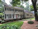 Charming two-story house with a manicured lawn, complemented by flowering bushes at 7260 Dunhill Ter, Atlanta, GA 30328