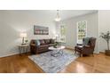 Cozy living room features hardwood floors, leather seating, and natural light from large windows at 2130 Federal Rd, Roswell, GA 30075