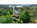 Stunning aerial view of a beautiful lake house surrounded by mature trees, with lush landscaping at 3865 Adams Rd, Cumming, GA 30041