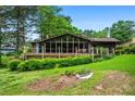 Charming lake house featuring a spacious wooden deck and large windows overlooking a lush yard at 3865 Adams Rd, Cumming, GA 30041