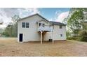 View of the house and raised deck from the back with a lot of green space at 645 Woodwind Dr, Rockmart, GA 30153