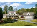 Beautiful exterior elevation of home with manicured lawn, circular driveway, and lush landscaping surrounding the property at 7305 Breeze Bay Rd, Cumming, GA 30041