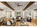 Expansive living area with hardwood floors, a large sectional sofa, stairs, and natural light throughout the space at 7305 Breeze Bay Rd, Cumming, GA 30041