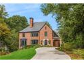 Charming brick two-story home with a manicured front lawn and covered driveway at 808 Lullwater Ne Rd, Atlanta, GA 30307